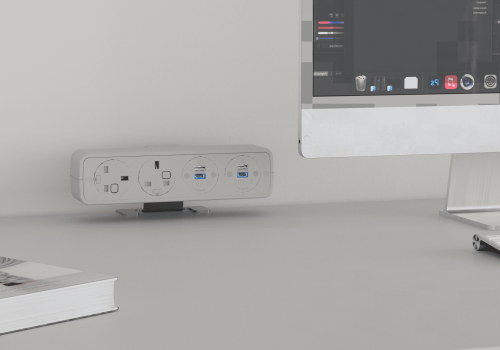 Workstation with an iMac on a stand and a white power strip with USB ports on the desk, plus a magazine in the foreground
